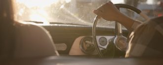 couple drive classic car during sunset