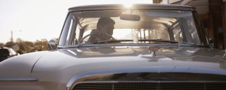 Couple driving classic car during sunset